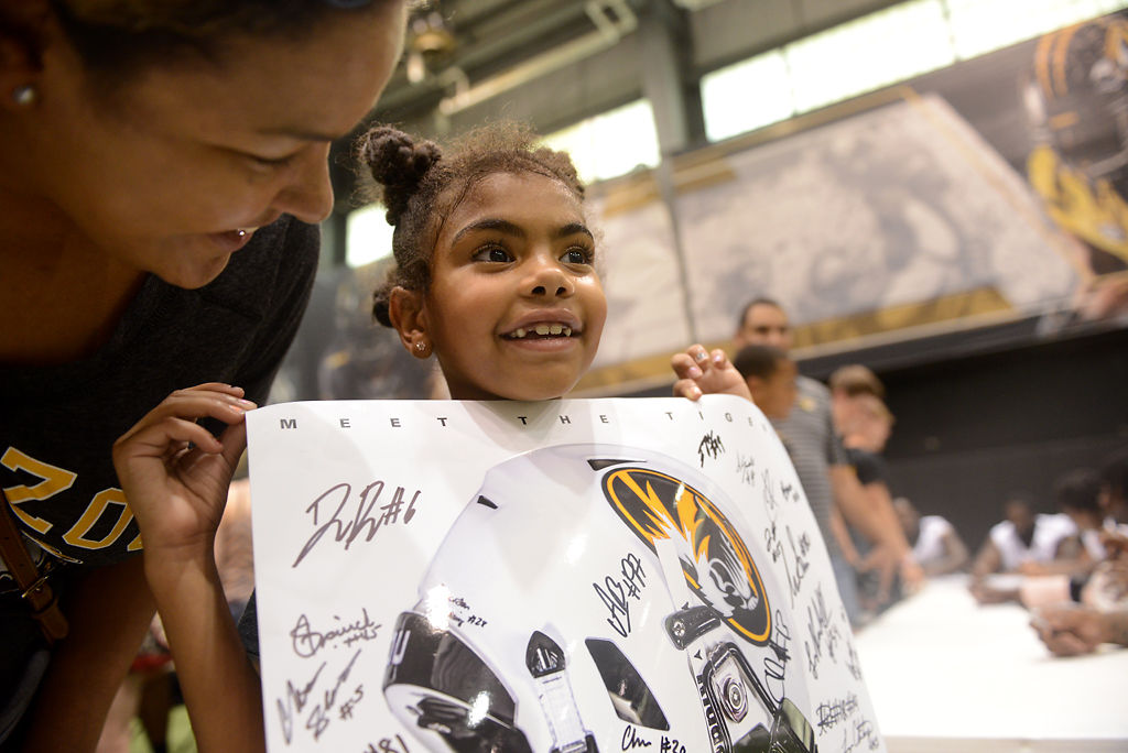 Jessica Jackson holds up her signed football poster